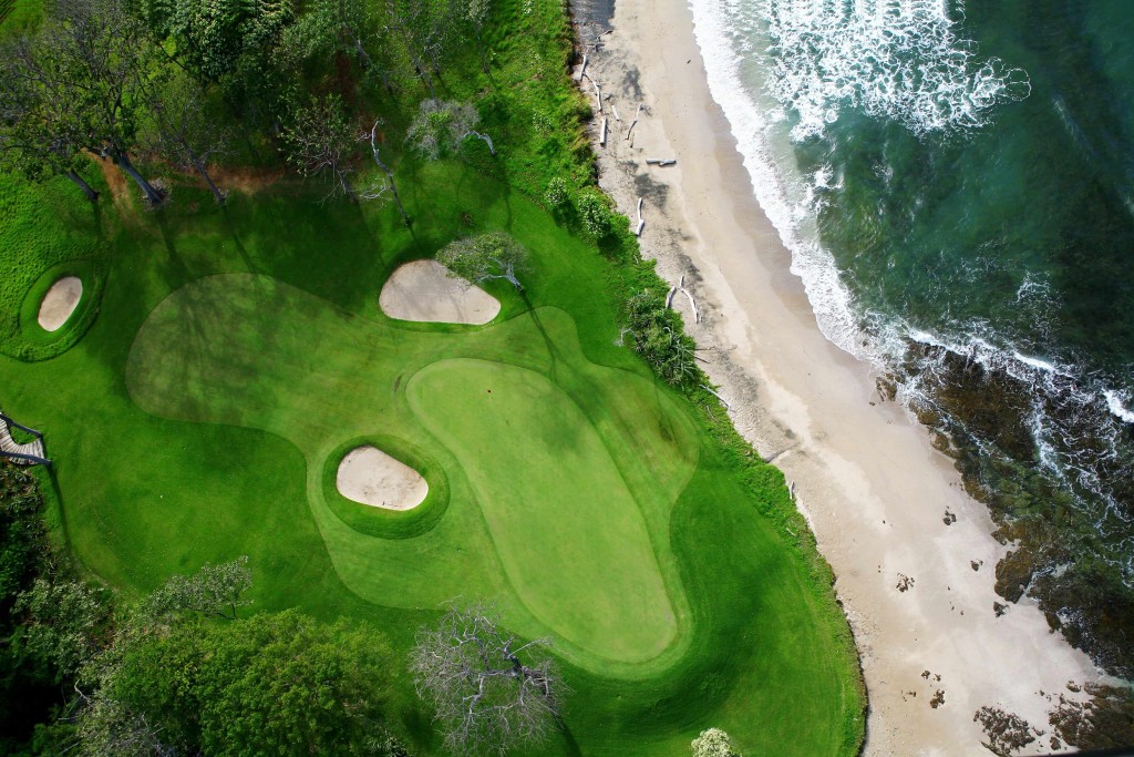 a green golf course right by the coast